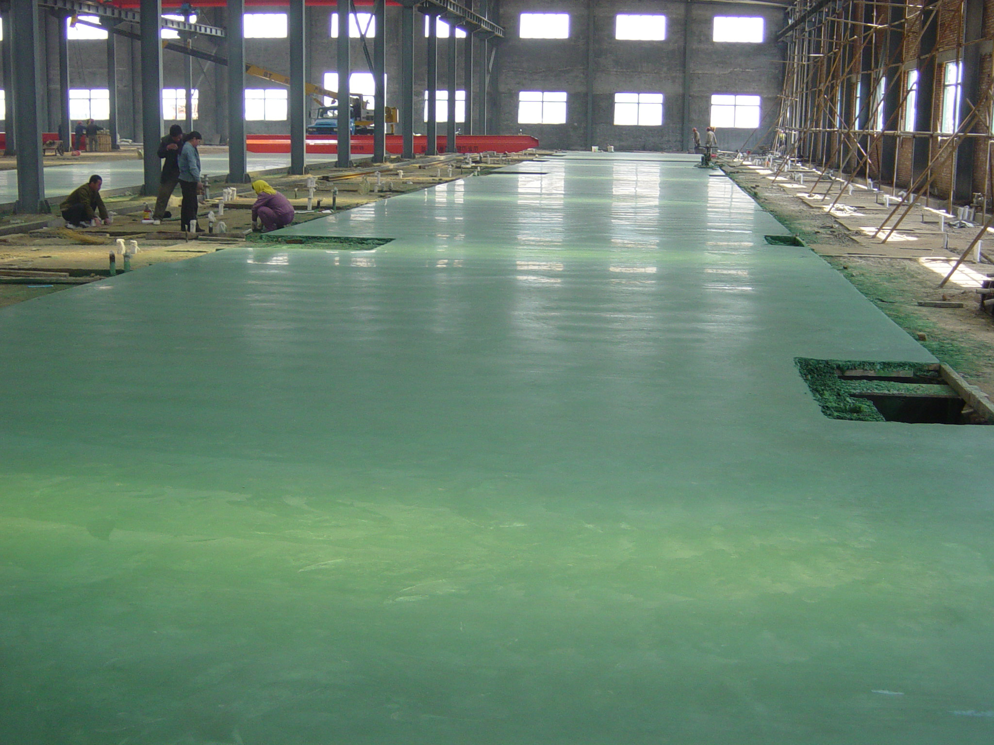 怛天九五车间施工中的金刚砂耐磨抗压地坪　